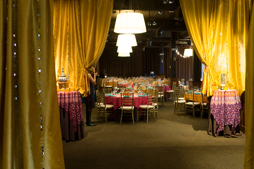 Caravale event photo showing Palace Ballroom decorated with mosaic table cloths, golden drapes, and flowers